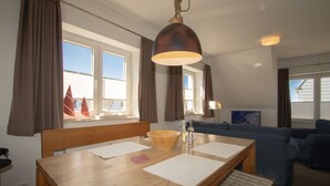 A dining area with a wooden table, a bowl, and a pendant light. - House Emilia app. lighthouse (Hörnum (Sylt))
