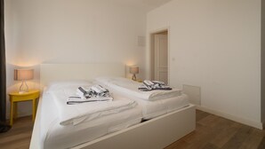 A hotel room with a double bed, two bedside tables, a lamp, and a telephone. - Holiday beacon (Hörnum (Sylt))