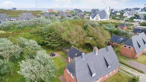 Et boligområde med huse, en kirke og en græsplæne.