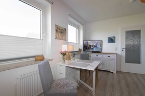 Ein kompakter Wohnbereich mit Esstisch, Fernseher und einer gemütlichen Sitzecke.