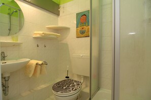 Ein Badezimmer mit Toilette, Waschbecken und Dusche.
