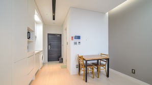 Une cuisine moderne avec des meubles blancs, une table en bois et des chaises.