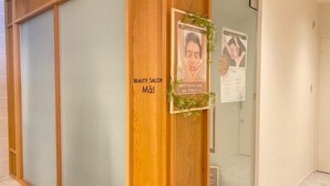 A hallway with a wooden door labeled "BEAUTY SALON Maki" and a poster with a price of 5000 yen. - Bibai ekimae hotel BIJIKO (Bibai)