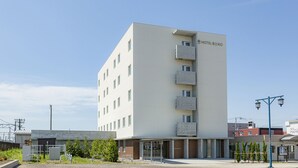 A modern hotel building with a flat facade, multiple balconies, and a clear sky. - Bibai ekimae hotel BIJIKO (Bibai)