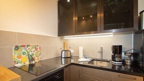 Una cocina moderna con electrodomésticos de acero inoxidable, un tostador y una cafetera.