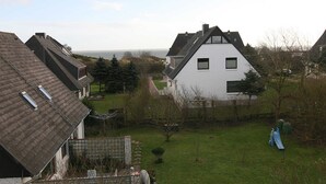A residential area with houses, a grassy yard, and a view of the sea. - House Schössler apartment 2 (Hörnum (Sylt))