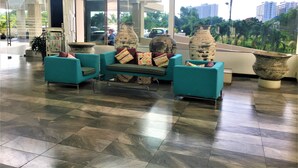 A lobby with teal chairs, large vases, and a tiled floor. - 1 bed at Angket Hip Residence (Pattaya)