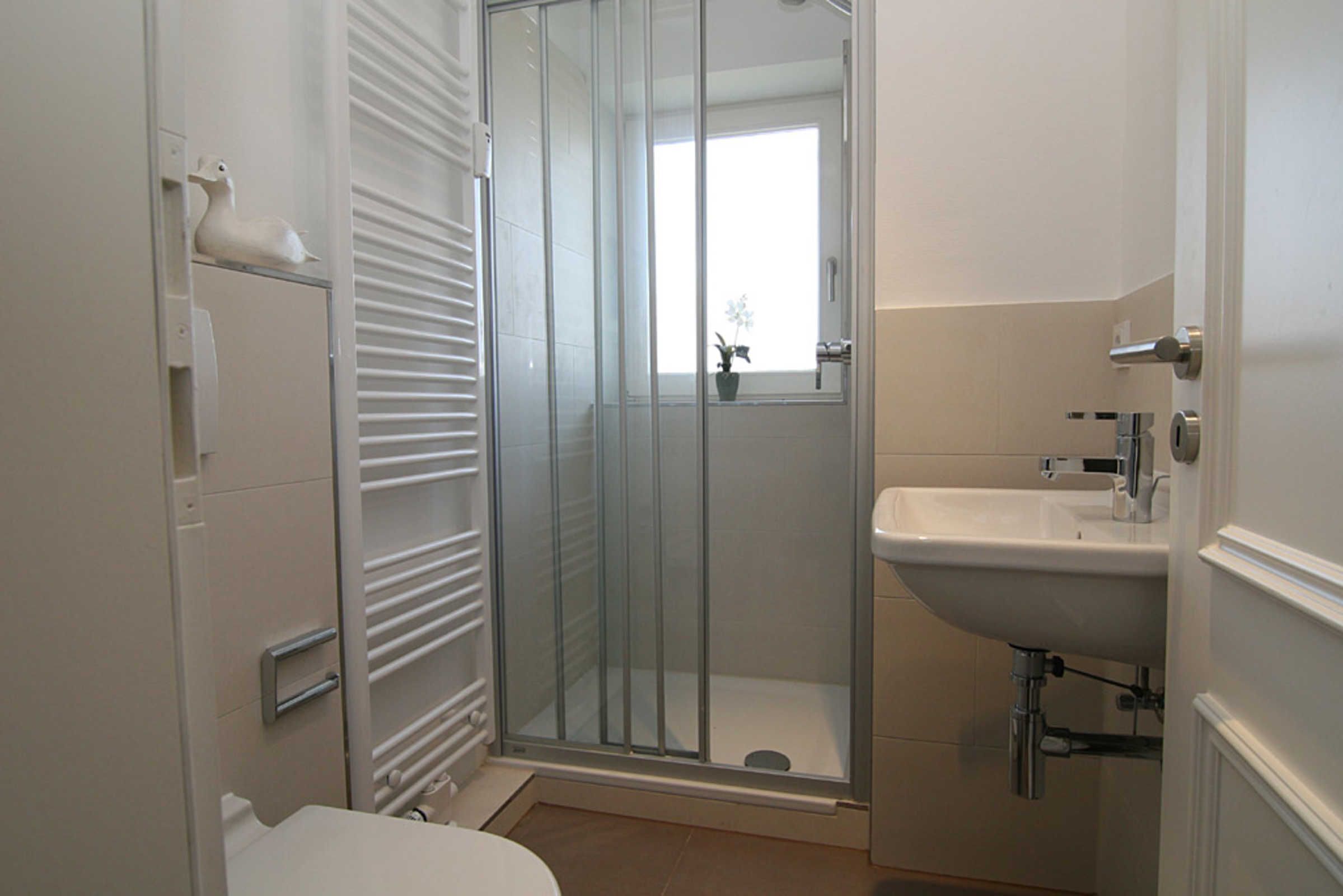 Une salle de bain avec une douche à parois de verre, des toilettes et un lavabo.