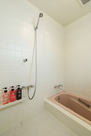 Un baño con bañera, ducha y estante con artículos de aseo.