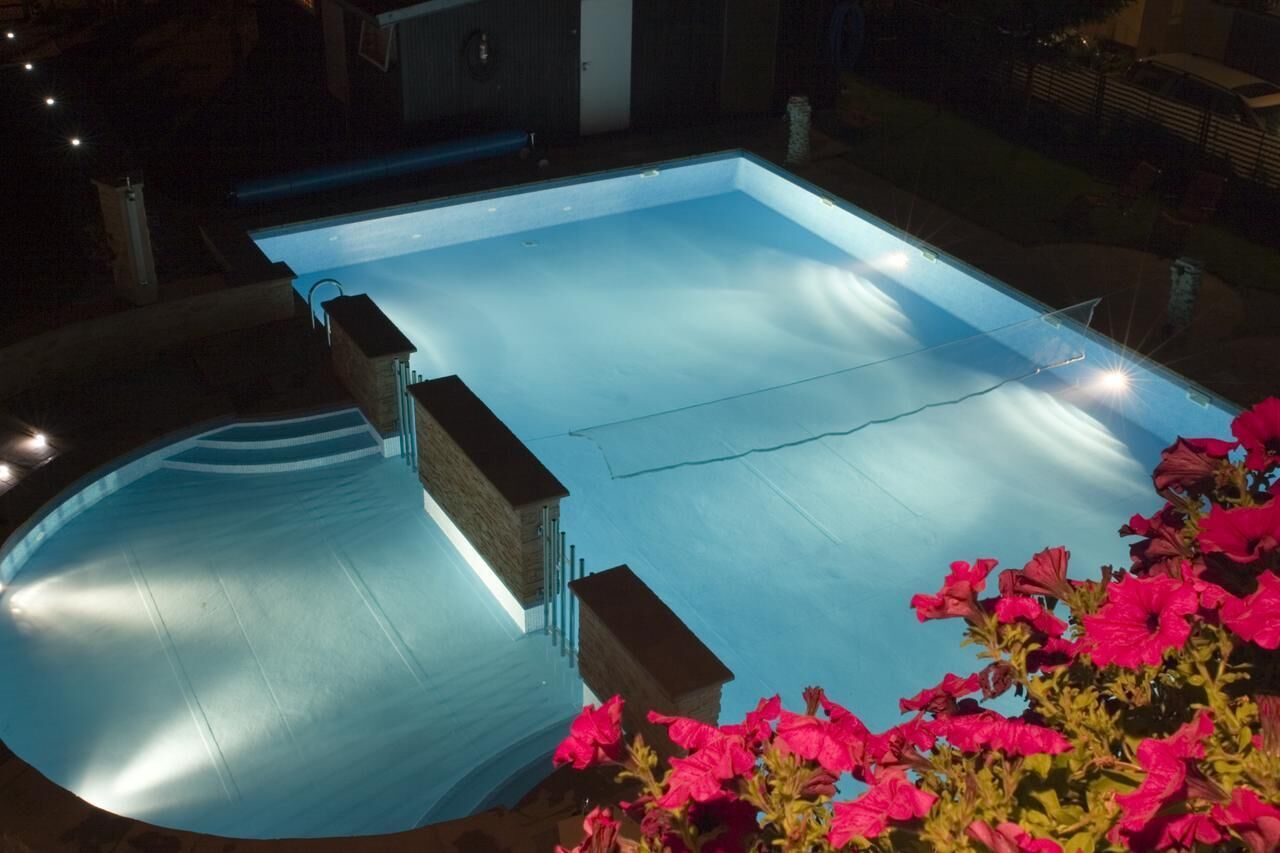 Piscina interior con agua cristalina, escalones de acceso y vistas del entorno.