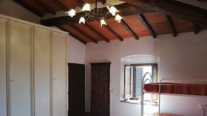 Ein Schlafzimmer mit einem Etagenbett, einem Kleiderschrank, einer Tür und einem Fenster mit Rollläden.