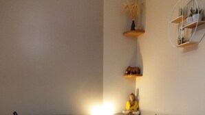 A living room with a dark-colored sofa, a small table with a lamp, a globe, and a shelf with books. - Apartment La Musette Historic Center of Dijon (Dijon)