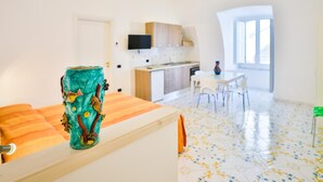 A modern room with a kitchen, dining area, and a large window.