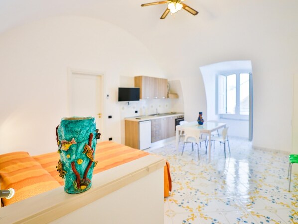 Une chambre moderne dotée d’une cuisine, d’un coin repas et d’une grande fenêtre.