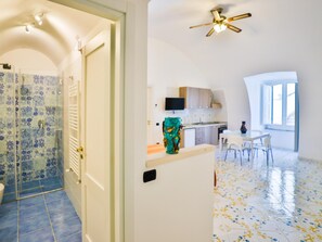 Une cuisine moderne avec un coin repas, un ventilateur de plafond et une vue sur l’extérieur.