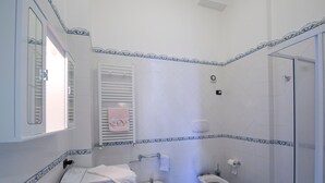 Un baño con lavamanos, bidé, inodoro y zona de ducha.