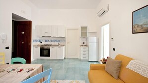 A compact living space with a kitchen, dining area, and a sofa.