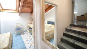 Ein Schlafzimmer mit Bett, Schreibtisch, Stuhl und Fenster.