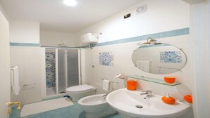 Ein Badezimmer mit Dusche, Toilette, Bidet und Waschbecken.