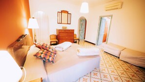 A hotel room with a bed, a dresser, a mirror, a lamp, and a door leading to another room. - House for 16 people Can Blay - private pool (Gualta)