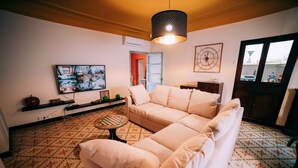 A living room with a beige sofa, a chess table, a television, and patterned flooring. - House for 16 people Can Blay - private pool (Gualta)