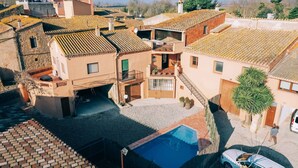 A residential area with a swimming pool, a car, and a staircase leading to a second-floor balcony. - House for 16 people Can Blay - private pool (Gualta)