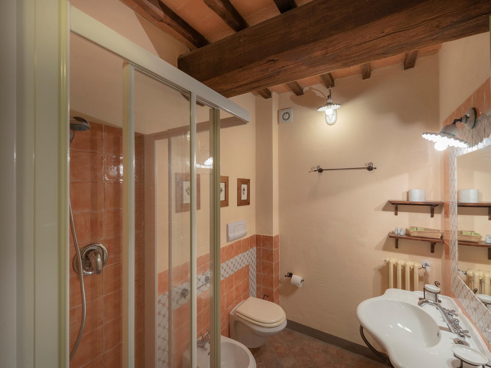 Une salle de bain avec une douche à parois de verre, des toilettes et un lavabo avec un miroir.