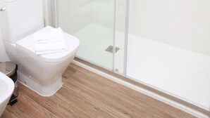 A modern bathroom with a glass-enclosed shower, a toilet, and a sink. - Exterior studio for 3 people (Madrid)