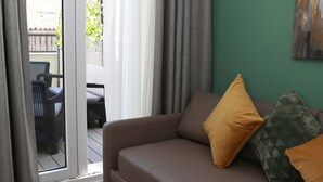 A room with a brown sofa, a white table, and a green wall. - One bedroom penthouse with terrace for 4 people (Madrid)