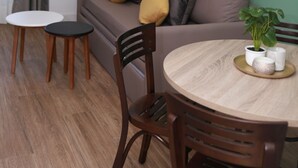 En moderne stue med sofa, to små borde og et spisebord med stole.