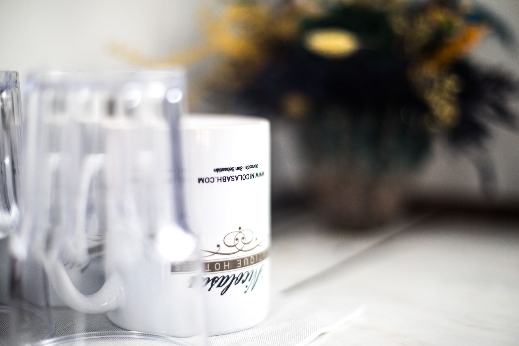 Two white mugs with text on them, placed on a table.
