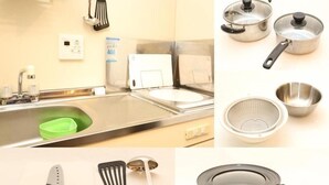 A kitchen with stainless steel appliances, a sink, and various utensils including a knife, spatula, and a frying pan. - Guesthouse Kyoto Yamashina (Kyoto)