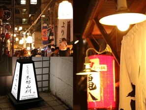 A traditional Japanese lantern and a signboard for a guesthouse.