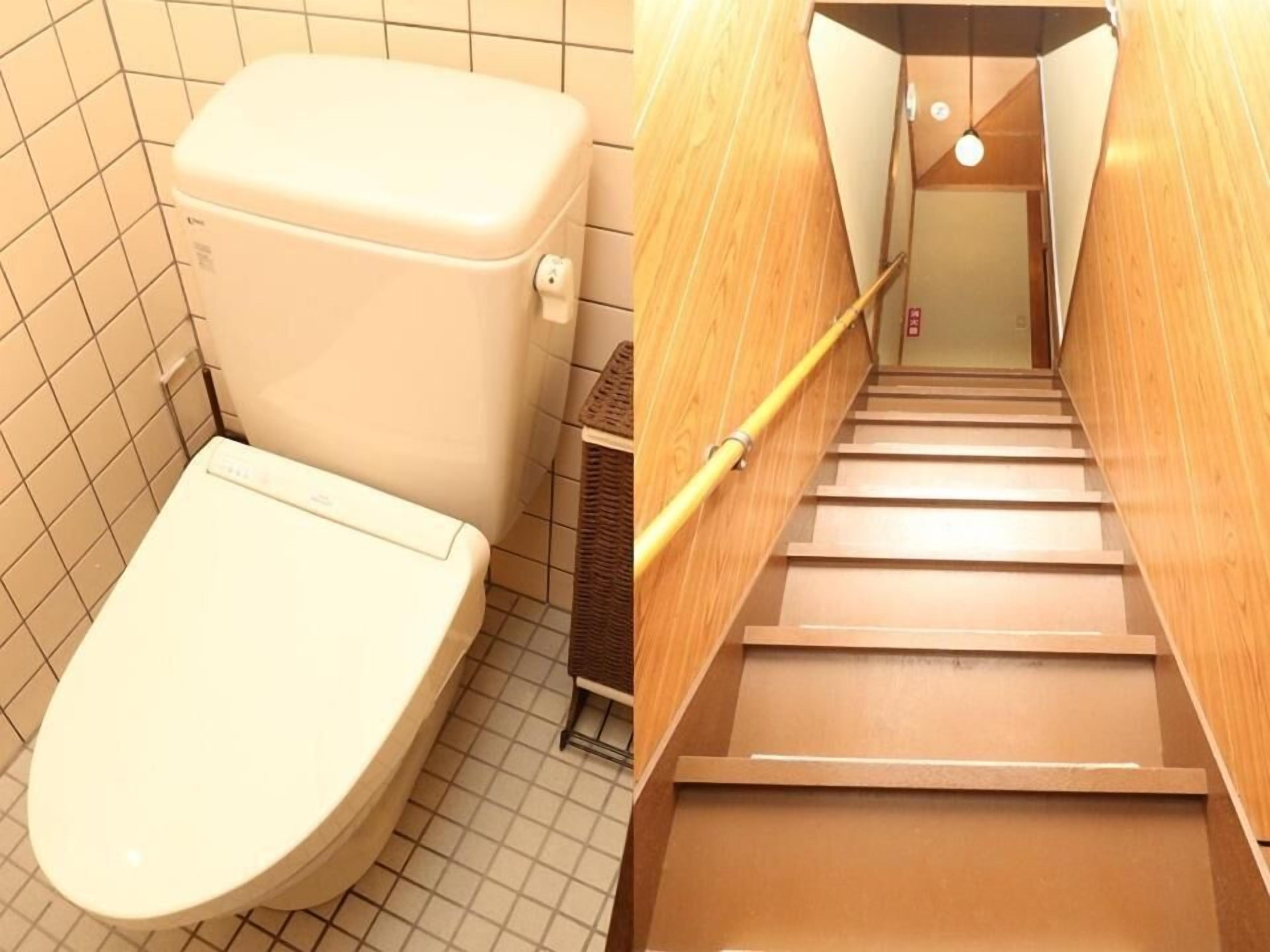 A bathroom with a toilet and a wooden staircase.