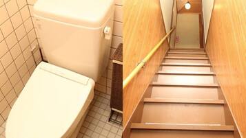 A bathroom with a toilet and a wooden staircase.