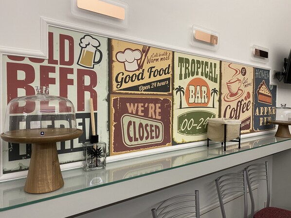 Zona de bar con un expositor de vidrio, una mesa de madera y un cartel que dice 'WE'RE CLOSED'.
