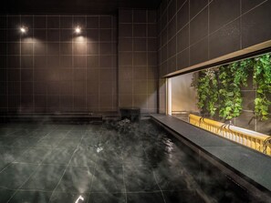 A spa area with a hot tub, tiled walls, and a view of greenery through a window. - Super Hotel Premier Shimonoseki (Shimonoseki)