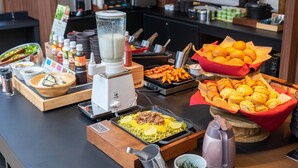 A buffet setup with various food items, a blender, and condiments. - Super Hotel Premier Shimonoseki (Shimonoseki)