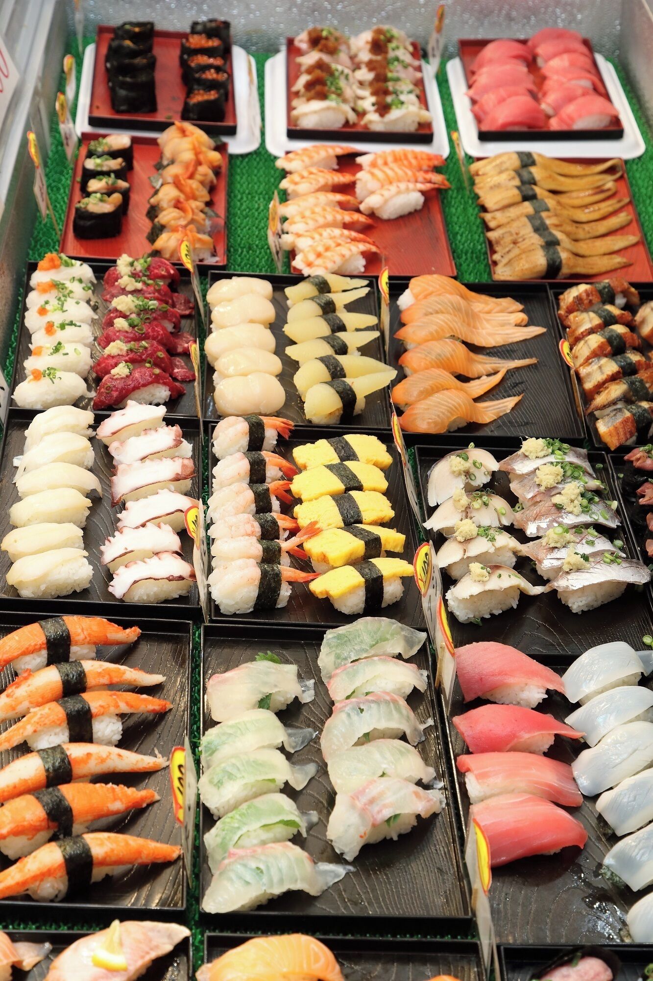 A variety of sushi dishes displayed on trays.