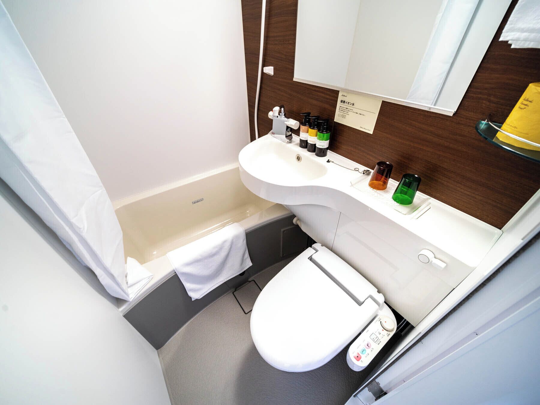 A compact bathroom with a bathtub, sink, and toilet.