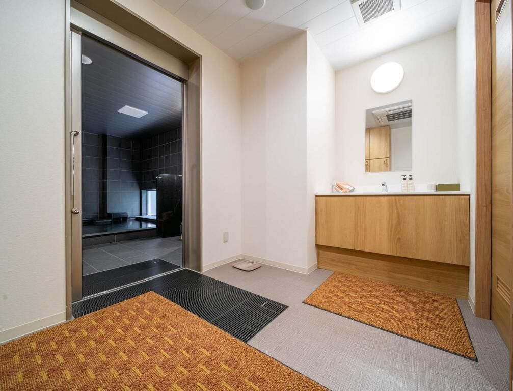 A hotel bathroom with a wooden vanity, a mirror, and a towel rack.