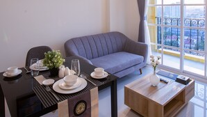 Una sala de estar moderna con comedor, un sofá, una mesa de centro y un balcón con barandilla.