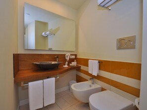 A modern bathroom with a wooden vanity, a large mirror, a bidet, and a toilet. - Casa Mao - ID 3308 - One Bedroom Hotel, Sleeps 3 (Amalfi)