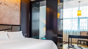 A modern hotel room with a large bed, a desk, and a chair. - Vyluk J Hotel Wanda Plaza Xiajie Street (Guangzhou)