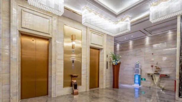 A lobby with three elevators, marble flooring, and a large chandelier. - Vyluk J Hotel Wanda Plaza Xiajie Street (Guangzhou)