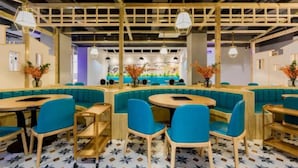 A modern restaurant with wooden beams, teal seating, and patterned flooring. - Vyluk J Hotel Wanda Plaza Xiajie Street (Guangzhou)