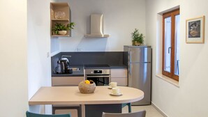 Une cuisine compacte dotée d’appareils électroménagers modernes, une table à manger avec des chaises et une fenêtre offrant une belle vue.