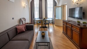 En moderne stue med sofa, sofabord, fjernsyn og spiseplads.