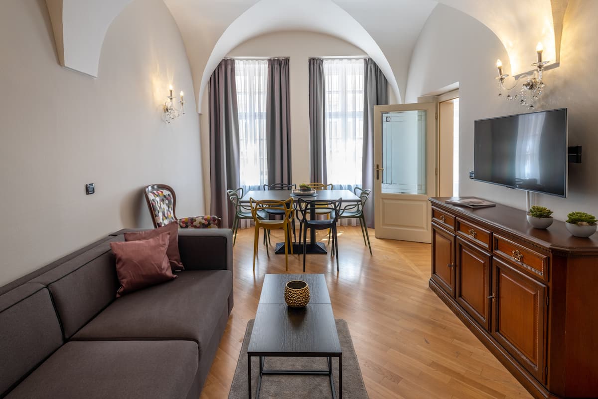Una sala moderna con sofá, mesa de centro, televisor y comedor.
