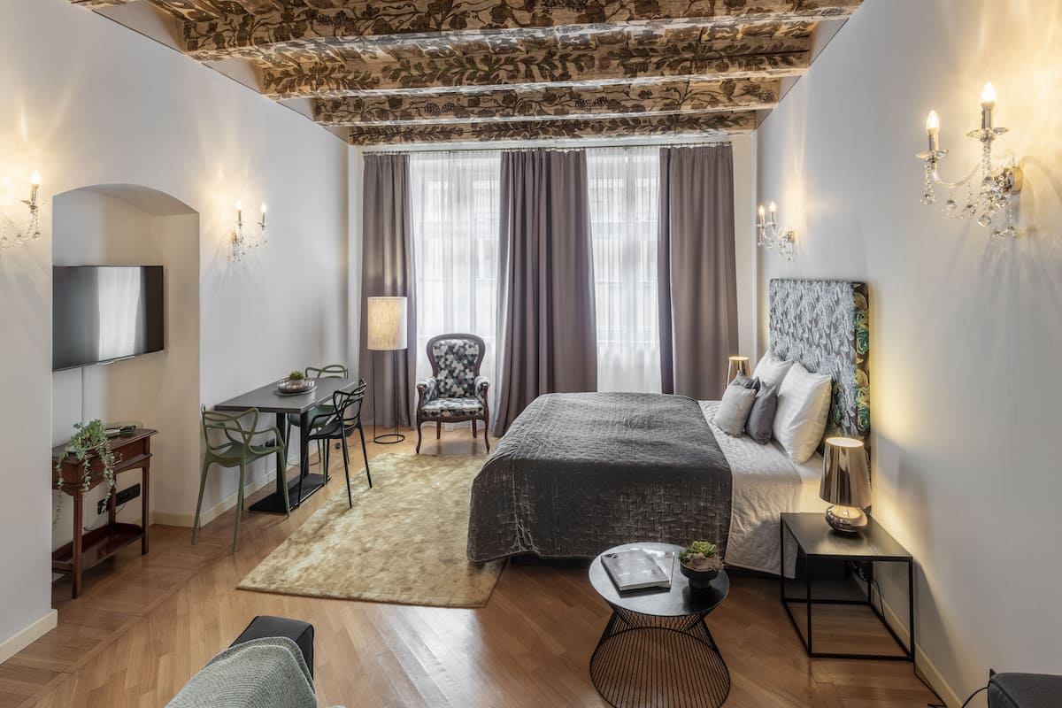 Un dormitorio moderno con cama, escritorio, silla y televisor.